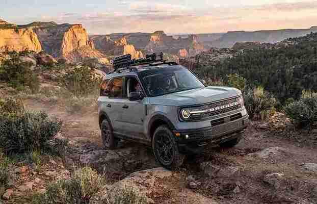 A gray Ford Bronco Sport driving through rugged terrain and rocky trails during an off-road adventure.